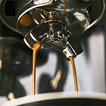 Rich espresso pouring from a group handle. 