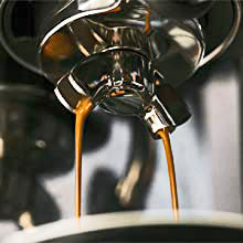 Rich espresso pouring from a group handle.