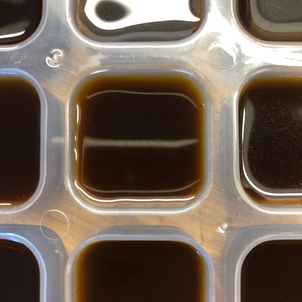 top view of ice cube tray filled with espresso to make coffee cubes